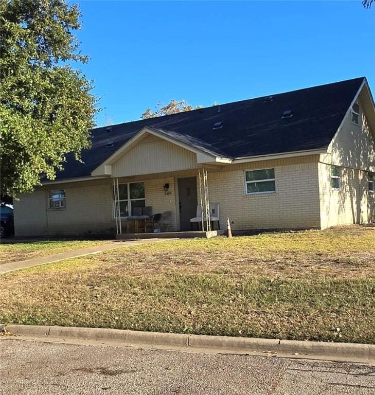 ranch-style house with a porch and a front lawn