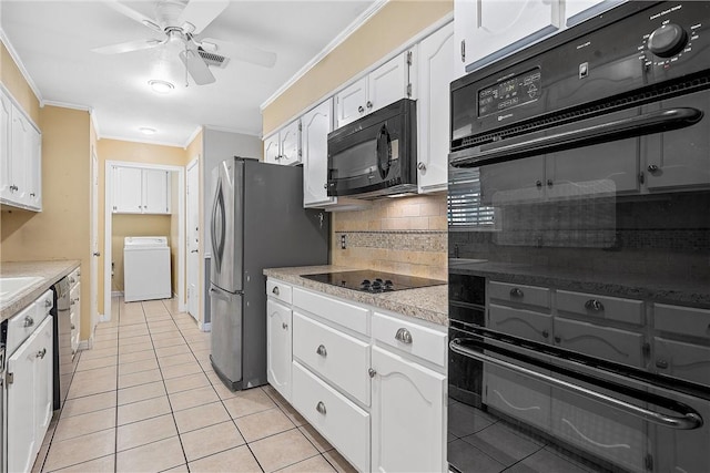 kitchen featuring light tile patterned floors, washer / dryer, decorative backsplash, white cabinets, and black appliances