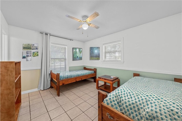 tiled bedroom featuring ceiling fan and multiple windows