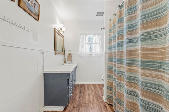 full bath featuring curtained shower, toilet, wood finished floors, vanity, and visible vents