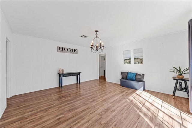 sitting room with visible vents, a chandelier, and wood finished floors