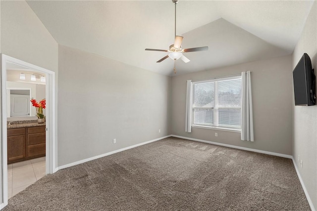 spare room featuring light colored carpet, ceiling fan, and vaulted ceiling