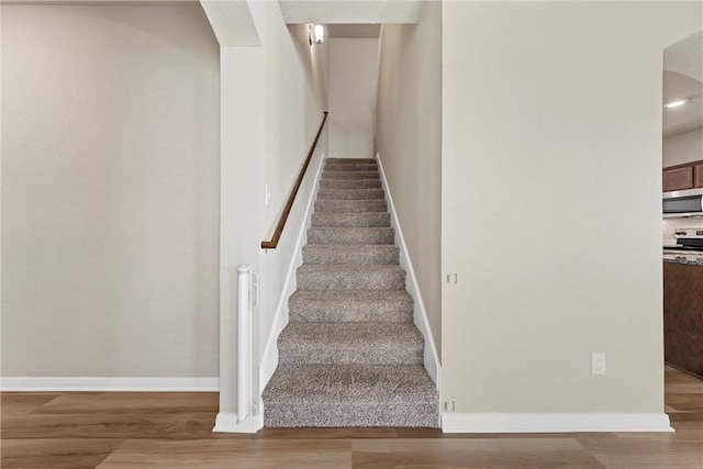 stairway featuring baseboards and wood finished floors