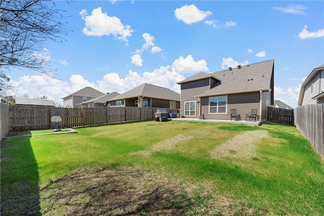 rear view of house with a patio, a lawn, and a fenced backyard