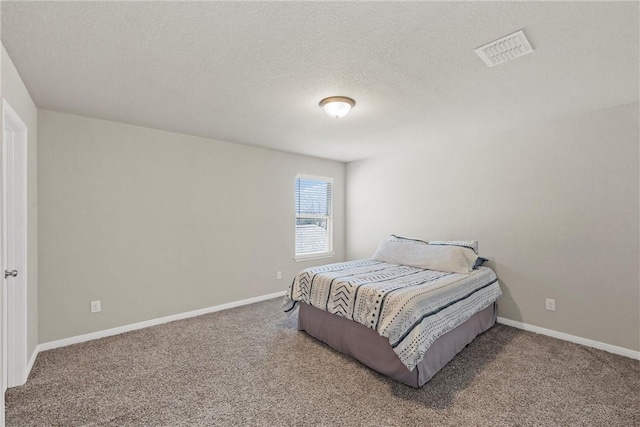 carpeted bedroom featuring visible vents, a textured ceiling, and baseboards