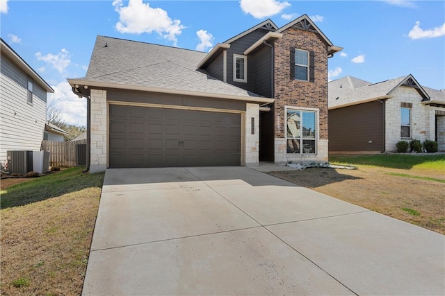 traditional home with a front lawn, stone siding, fence, concrete driveway, and an attached garage