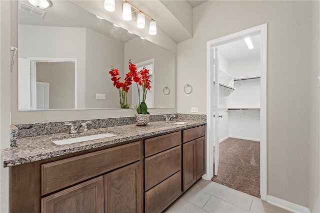 full bath featuring a sink, visible vents, double vanity, and tile patterned flooring