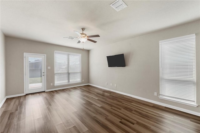 unfurnished living room with visible vents, wood finished floors, baseboards, and ceiling fan