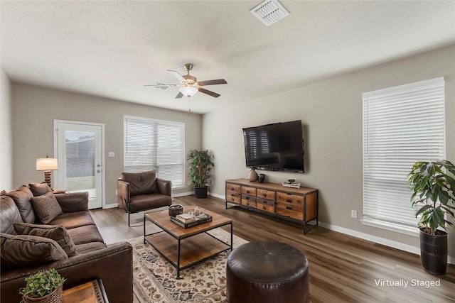 living room with visible vents, baseboards, a ceiling fan, and wood finished floors