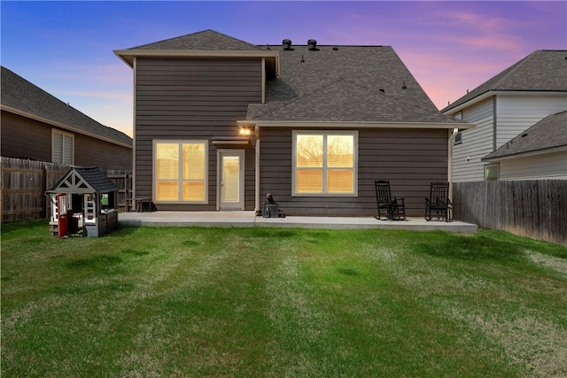 back of property with a patio area, a fenced backyard, and a yard