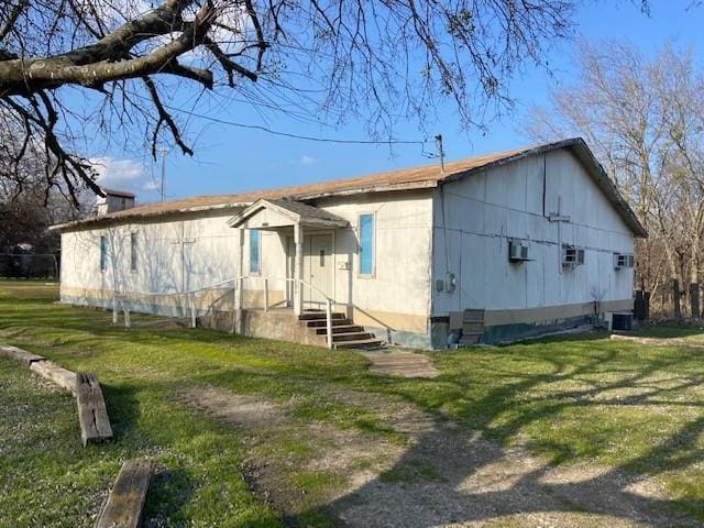 exterior space with a front lawn and central AC unit