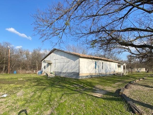 view of side of property with entry steps and a yard