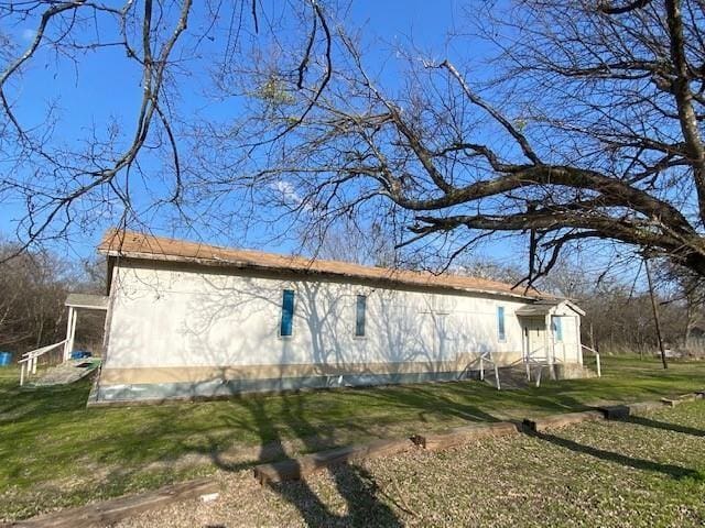 view of side of home with a yard