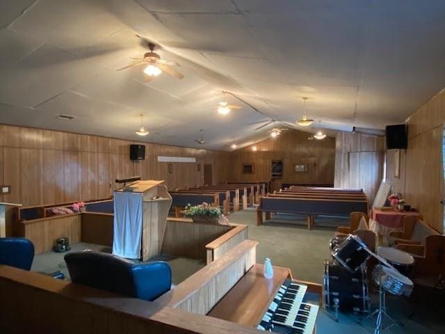 game room with vaulted ceiling, wood walls, and carpet