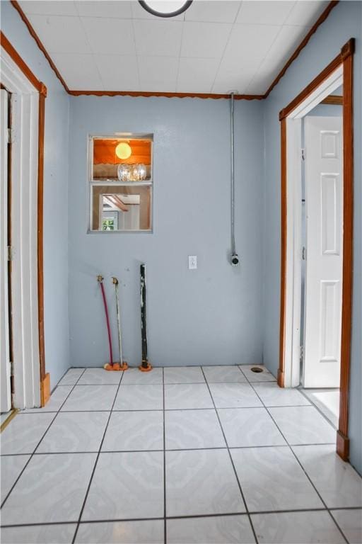 hallway with ornamental molding and light tile patterned flooring