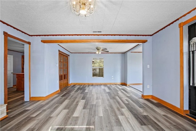 unfurnished room featuring hardwood / wood-style flooring, ceiling fan with notable chandelier, and crown molding