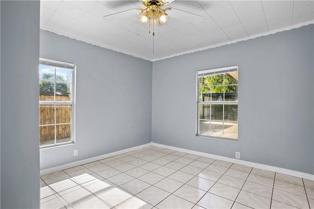 tiled empty room with ceiling fan and ornamental molding