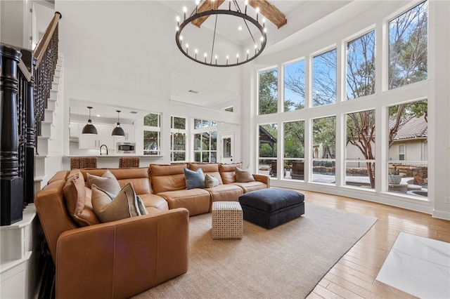 sunroom / solarium with a sink and a notable chandelier