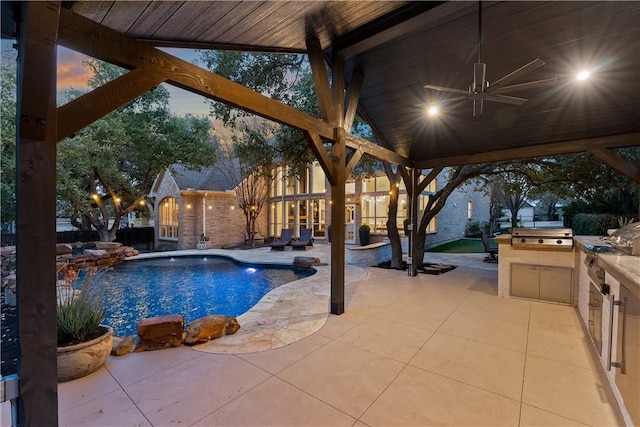 pool with a patio area, a ceiling fan, exterior kitchen, and area for grilling