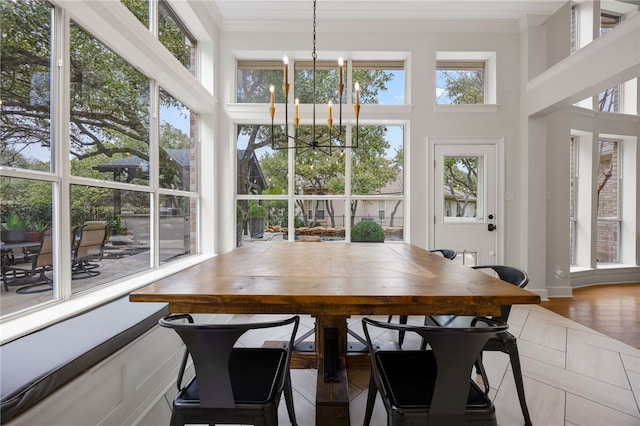 sunroom featuring a healthy amount of sunlight and an inviting chandelier