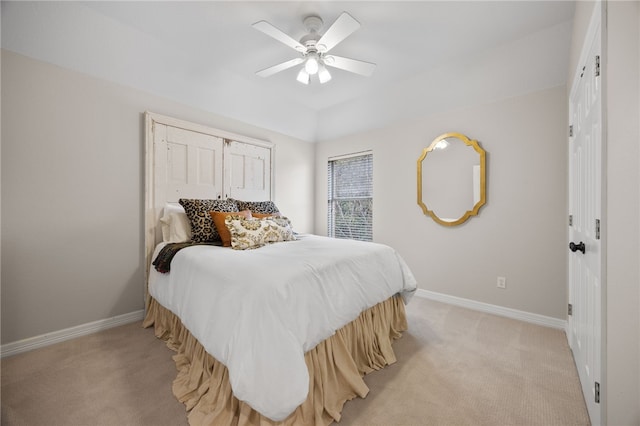 bedroom with light carpet, ceiling fan, and baseboards