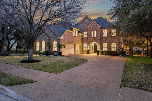 view of front of home featuring central AC, brick siding, fence, concrete driveway, and a front lawn