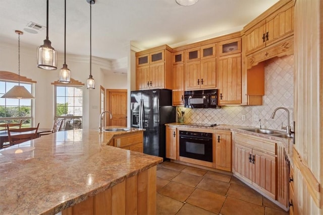 kitchen featuring light stone countertops, sink, decorative light fixtures, and black appliances