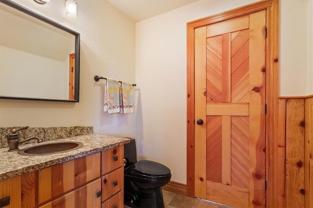 bathroom featuring tile patterned floors, vanity, and toilet