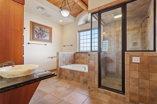 bathroom with beamed ceiling, shower with separate bathtub, tile patterned floors, and sink