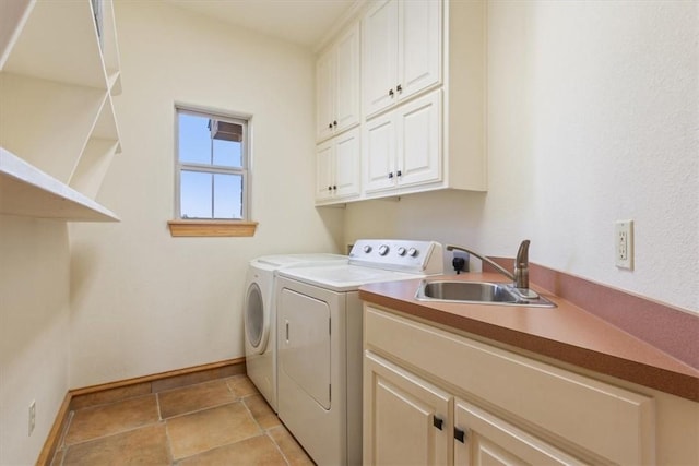 laundry room featuring washer and dryer, cabinets, and sink