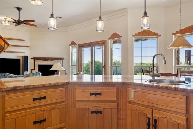 kitchen with crown molding, sink, ceiling fan, and pendant lighting