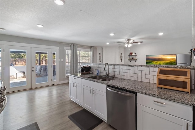 kitchen featuring appliances with stainless steel finishes, french doors, sink, dark stone countertops, and white cabinetry