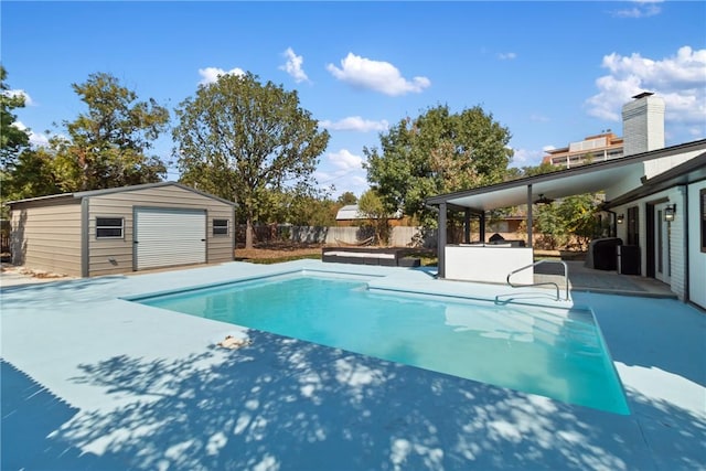 view of swimming pool with ceiling fan, a patio, and a shed