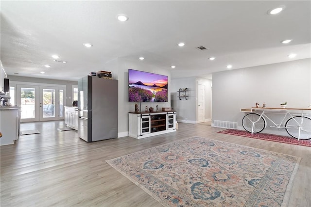 living room with light hardwood / wood-style flooring and french doors