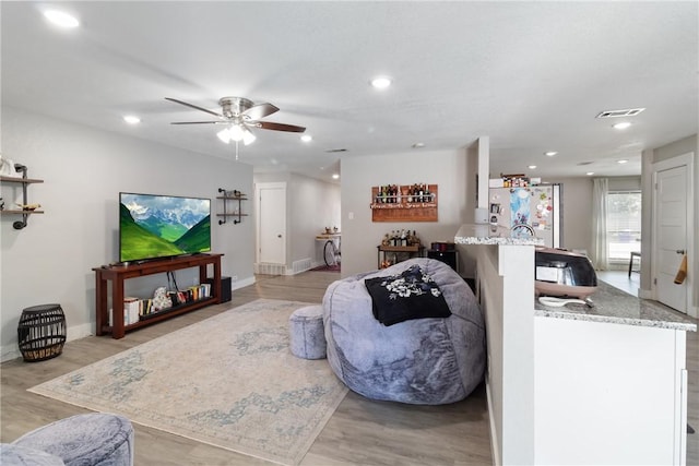 living room featuring ceiling fan and light wood-type flooring