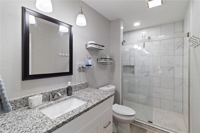 bathroom featuring vanity, toilet, and a shower with shower door