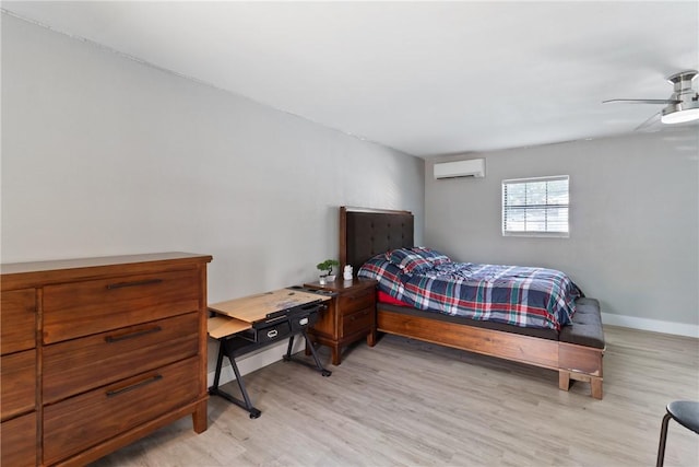 bedroom with light hardwood / wood-style flooring, ceiling fan, and a wall unit AC