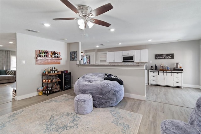 living room featuring ceiling fan and light wood-type flooring