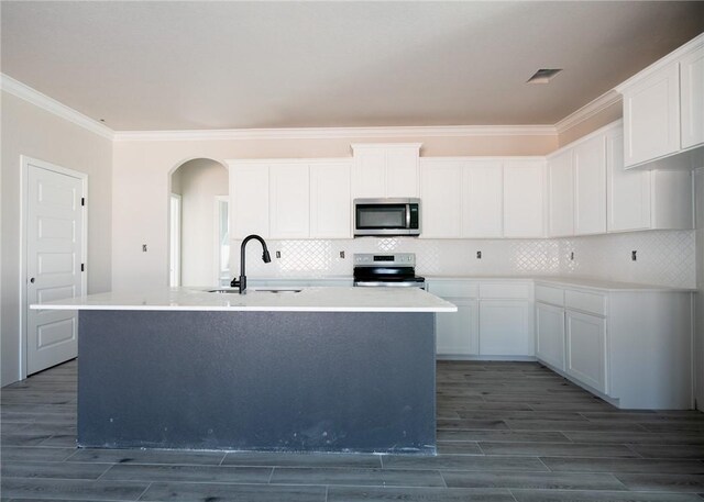 kitchen featuring stainless steel appliances, white cabinetry, and an island with sink