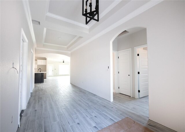 corridor with light hardwood / wood-style floors and sink