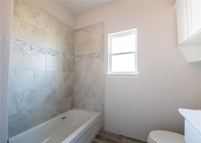 full bathroom featuring hardwood / wood-style flooring, vanity, toilet, and tiled shower / bath combo