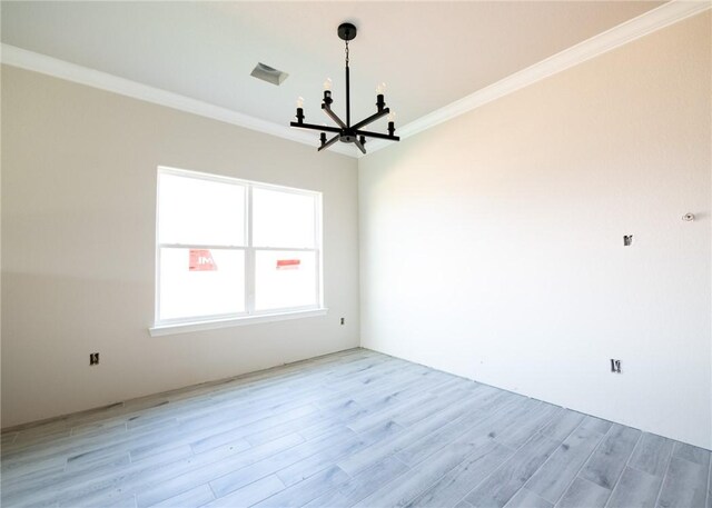 empty room with light hardwood / wood-style floors, a notable chandelier, and ornamental molding