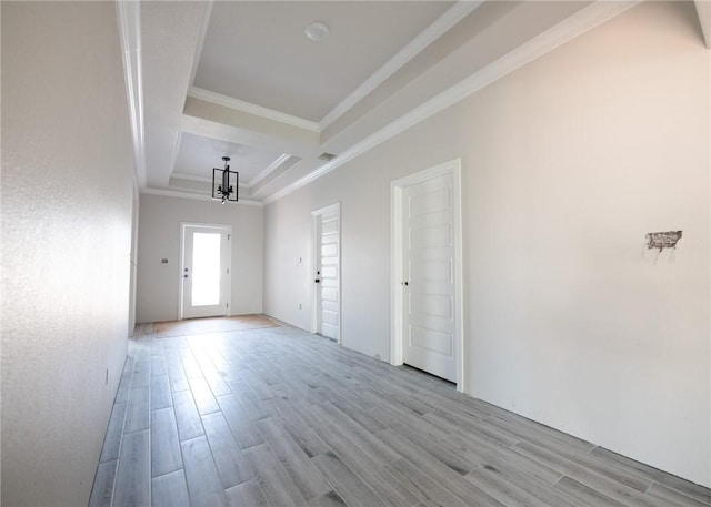 spare room featuring light hardwood / wood-style flooring, an inviting chandelier, and ornamental molding