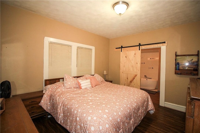 bedroom with a barn door and dark wood-type flooring