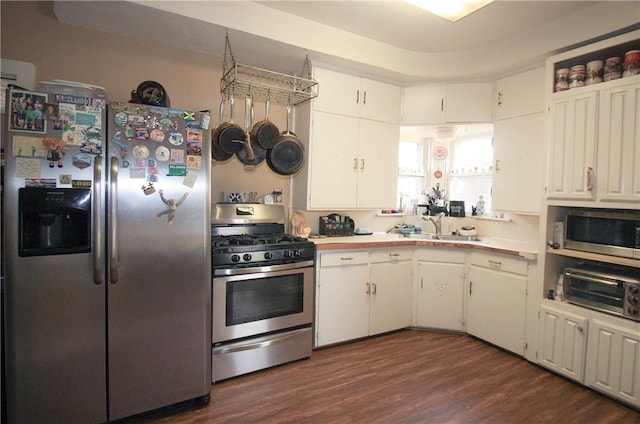 kitchen with white cabinets, stainless steel appliances, dark hardwood / wood-style floors, and sink