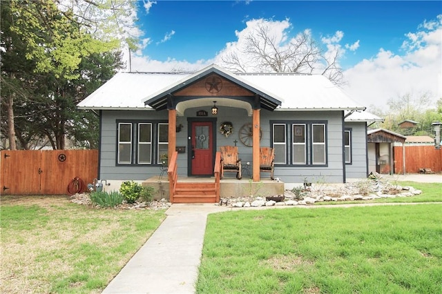 bungalow-style home with covered porch and a front lawn