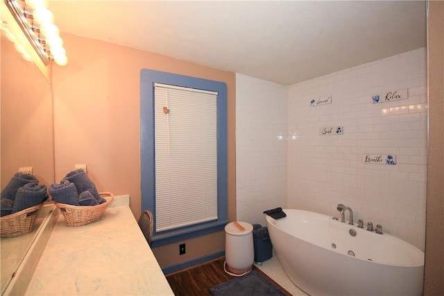 bathroom featuring hardwood / wood-style floors, vanity, and a tub to relax in