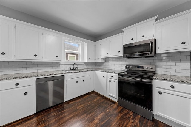 kitchen featuring sink, dark wood-type flooring, white cabinetry, stainless steel appliances, and tasteful backsplash