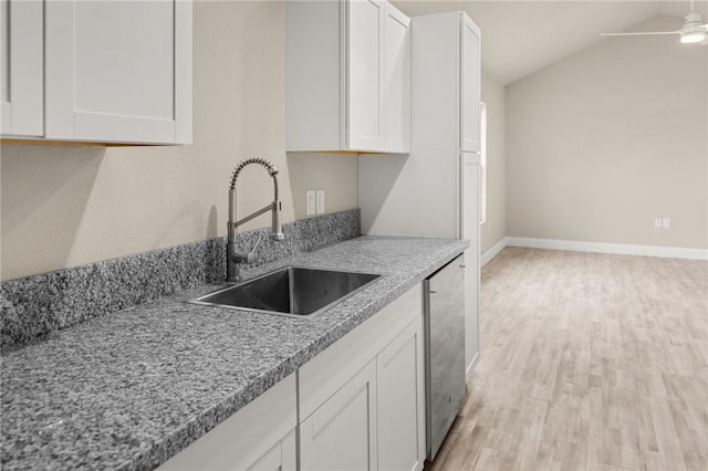 kitchen featuring sink, white cabinets, and lofted ceiling