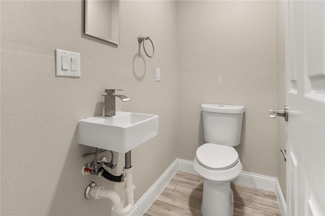 bathroom with wood-type flooring and toilet